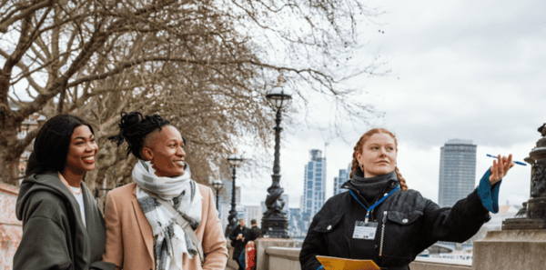 A woman tour guide gesturing to show two guests A woman tour guide gesturing to show two guests